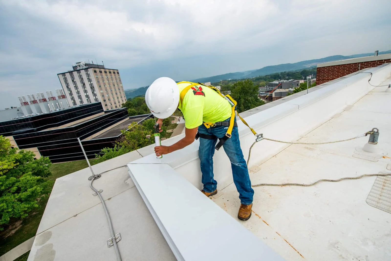 Technician inspecting a low-slope roof seam